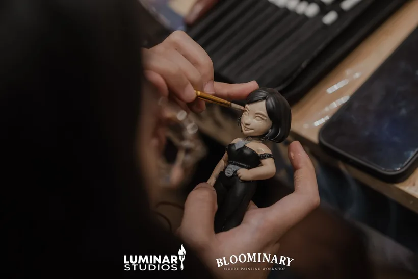 Brush painting the facial features of a custom BINI 3D figurine