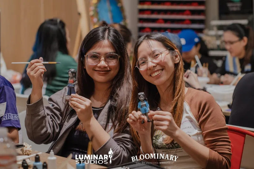 Workshop attendees smiling with their completed BINI custom figures