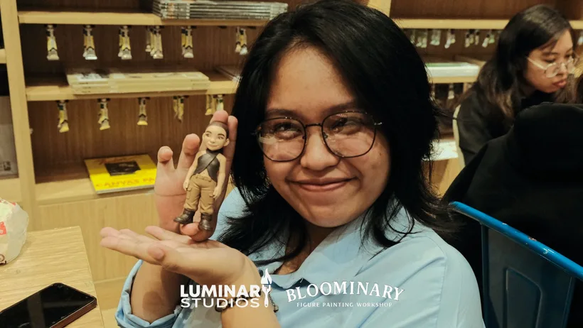 Painter smiling while holding a finished BINI 3D printed figure