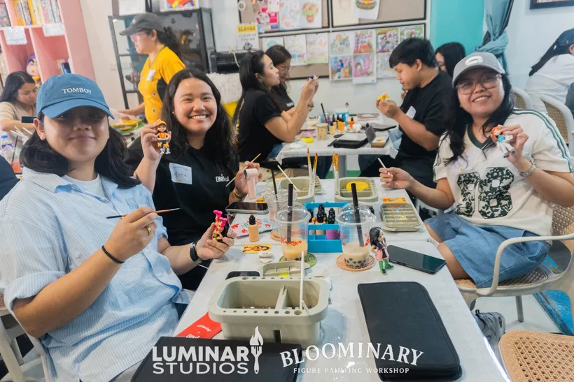 Painters smiling with finished BINI figures at Kureyon Creative Space
