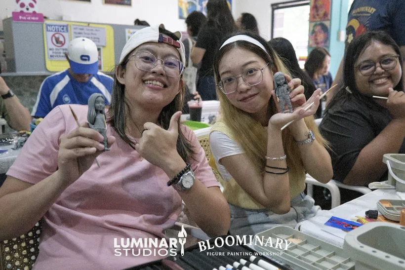 Attendees smiling with finished BINI 3D resin figurines and thumbs-up