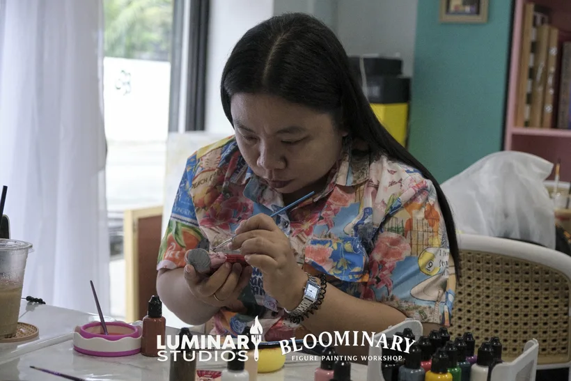 Painter focused on fine detail work on a BINI 3D printed miniature