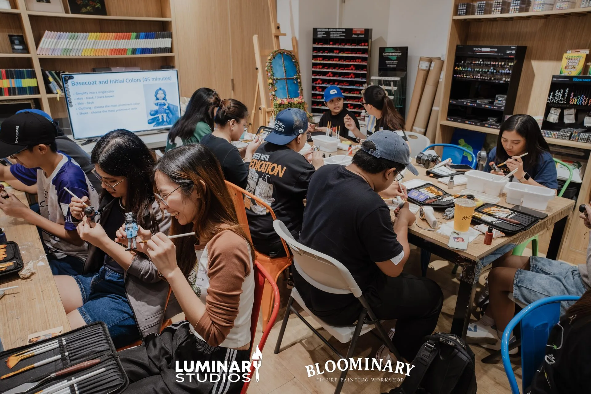 Students painting figures together at a Bloominary workshop